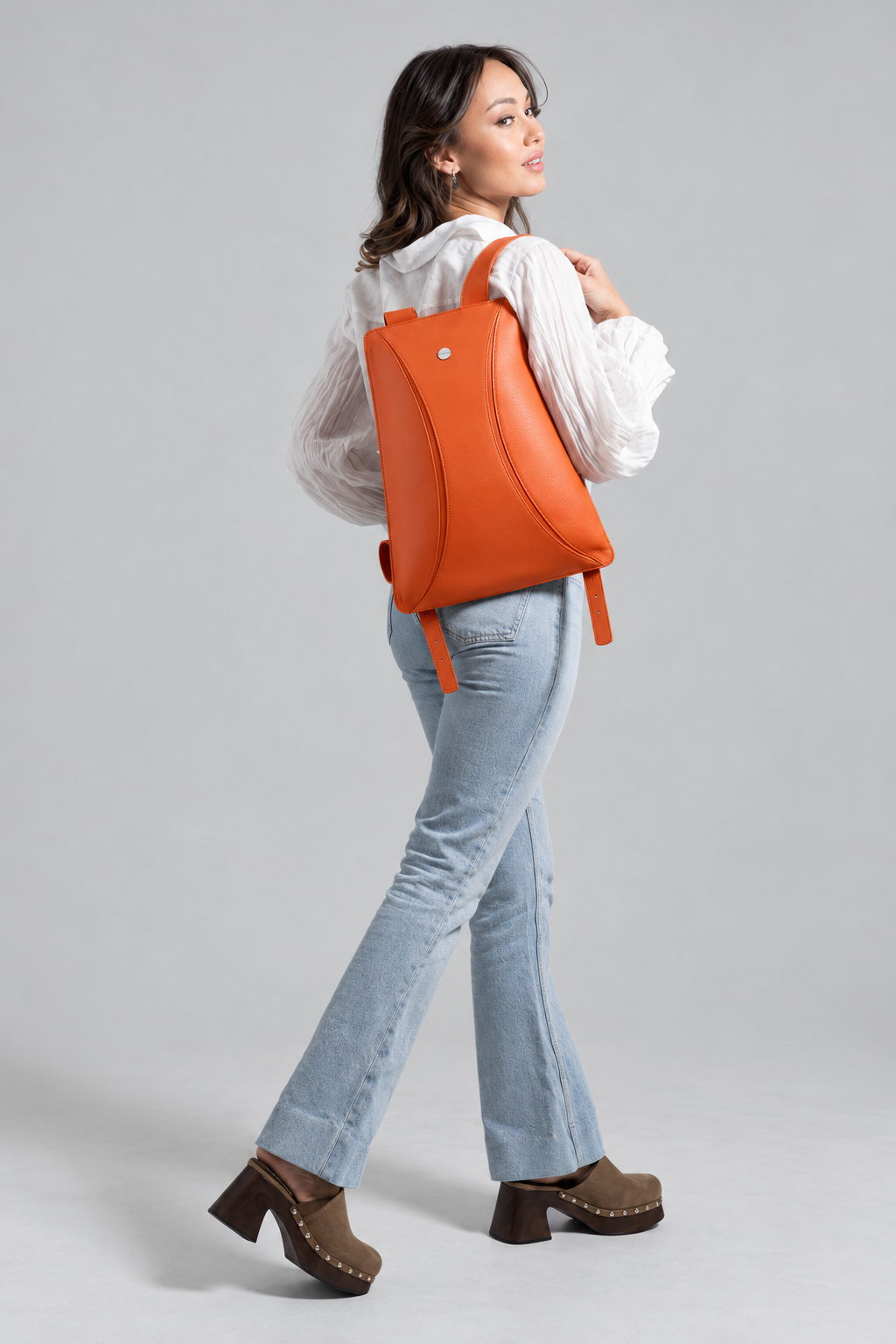 Vista de cuerpo entero con el bolso naranja llevado a la espalda