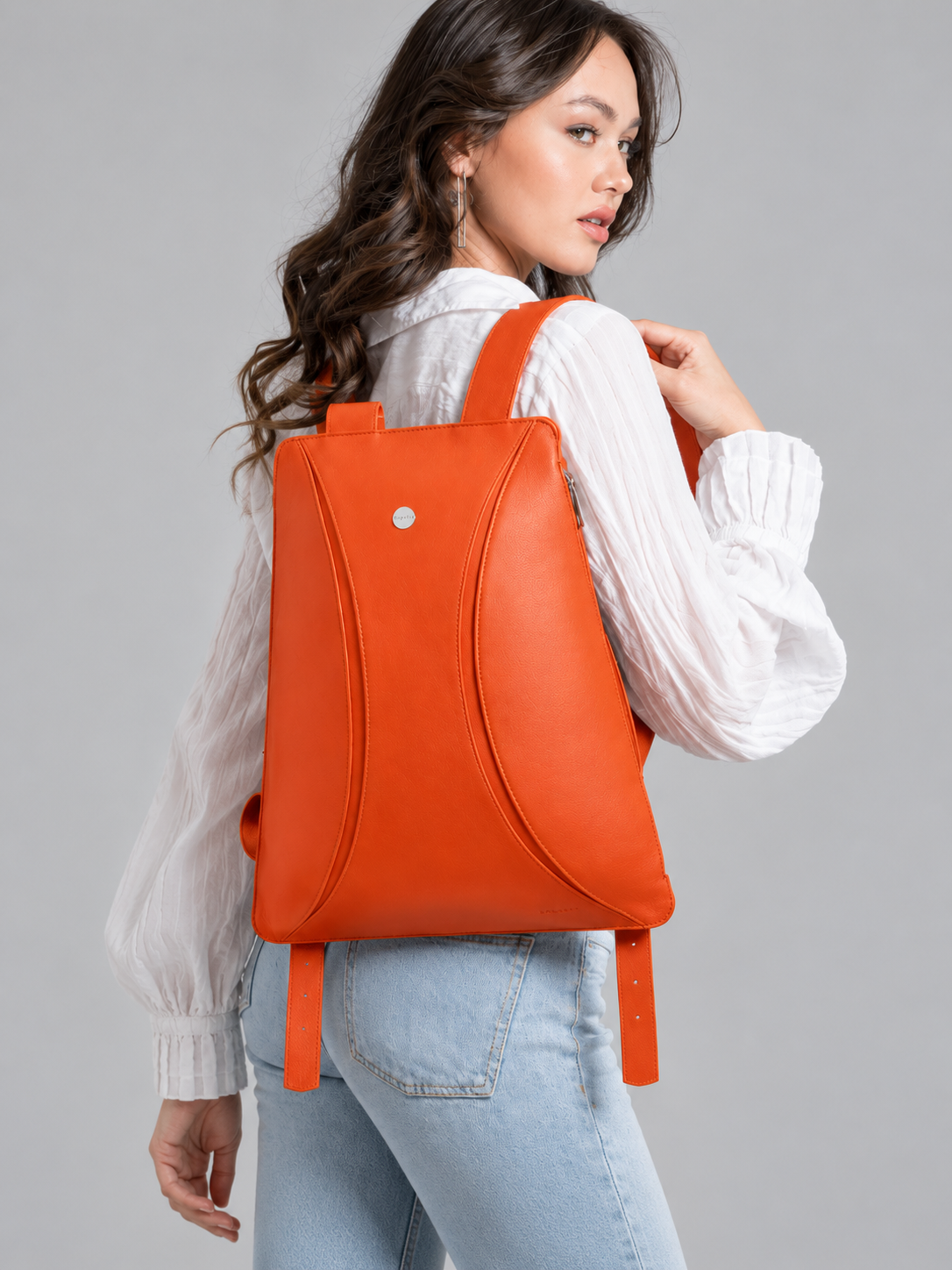 Bolso naranja de Joaquín Espaliú llevado a la espalda, vista de tres cuartos